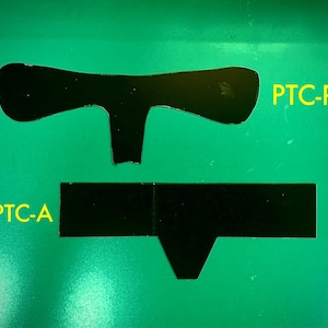 May include: Two black, rectangular shapes on a green background. The top shape is a T-shape with the text "PTC-R" to the right. The bottom shape is a long rectangle with a small V-shape at the bottom. The text "PTC-A" is to the left of the bottom shape.
