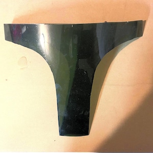 May include: A black plastic automotive part shaped like a V. The part has a smooth, glossy finish.