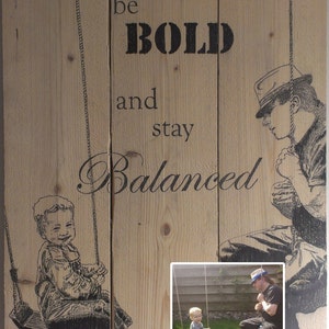 May include: A wooden sign with the text "be BOLD and stay Balanced" printed on it. The sign features two illustrations of people on swings. One illustration is of a man in a hat and the other is of a child.