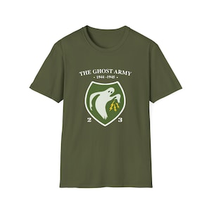 May include: A green t-shirt with a white graphic of a ghost holding lightning bolts. The graphic is inside a green shield with the text "THE GHOST ARMY" and "1944-1945" above it and the numbers "2" and "3" below it.