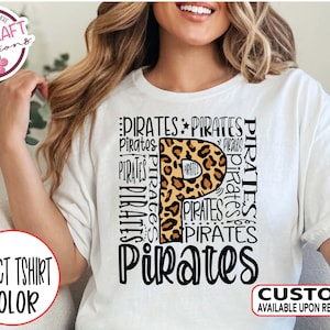 May include: White t-shirt with a black and brown leopard print letter "P" surrounded by the word "Pirates" repeated in various sizes and orientations.