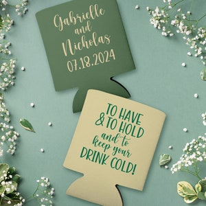 May include: Two green and tan can coolers. The green cooler has the text 'Gabrielle and Nicholas 07.18.2024' on it. The tan cooler has the text 'TO HAVE & TO HOLD and to keep your DRINK COLD!' on it.