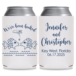May include: Two white can coolers with blue text and illustrations. The cooler on the left has two fish kissing with a fishing line and bobber above them. The text reads 'We've been hooked'. The cooler on the right has the text 'Jennifer and Christopher Key West, Florida 06.17.2025'.