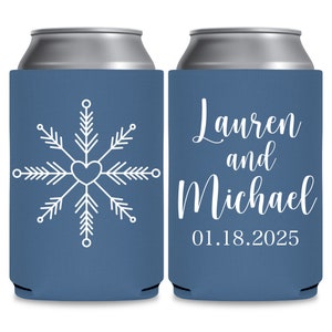May include: Two blue can coolers with white text and designs. The cooler on the left has a snowflake design with a heart in the center. The cooler on the right has the text 'Lauren and Michael 01.18.2025'.