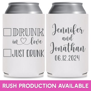 May include: Two white can coolers with black text. The cooler on the left has a checkbox next to the text 'DRUNK in love' and another checkbox next to the text 'JUST DRUNK'. The cooler on the right has the text 'Jennifer and Jonathan 06.12.2024'.