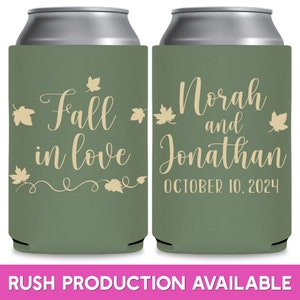May include: Two green and beige can coolers with a fall wedding theme. The left cooler says 'Fall in love' with a vine and leaves design. The right cooler says 'Norah and Jonathan' with the date 'October 10, 2024'.