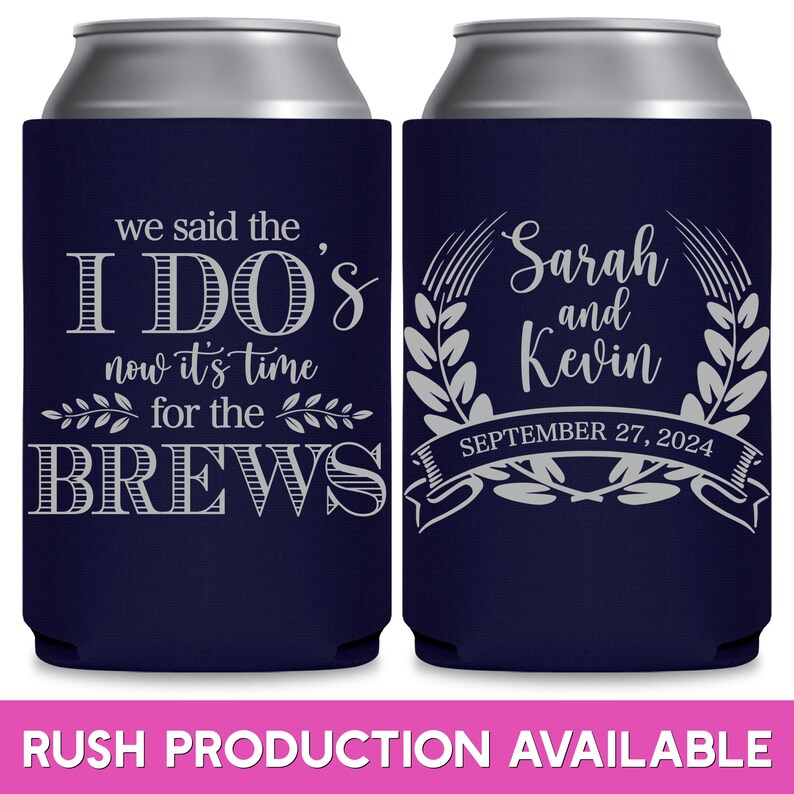 May include: Two navy blue can coolers. The cooler on the left has the text 'we said the I DO'S now it's time for the BREWS' in gray. The cooler on the right has a wreath with the text 'Sarah and Kevin' and 'SEPTEMBER 27, 2024' in gray.