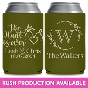 May include: Two green can coolers with white text. The cooler on the left has a deer head and heart design and the text 'The Hunt is Over', 'Leah & Chris', and '10.07.2024'. The cooler on the right has a wreath with the letter 'W' in the center and the text 'The Walkers'.
