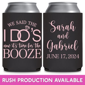 May include: Two black can coolers with pink text. The first cooler says 'We said the I DO'S now it's time for the BOOZE'. The second cooler says 'Sarah and Gabriel JUNE 17, 2024'.  The coolers are for a wedding or bridal shower.