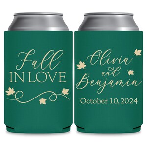 May include: Two green can coolers with white text. The left cooler says 'Fall in Love' with a vine and leaves design. The right cooler says 'Olivia and Benjamin' with a date of 'October 10, 2024'.