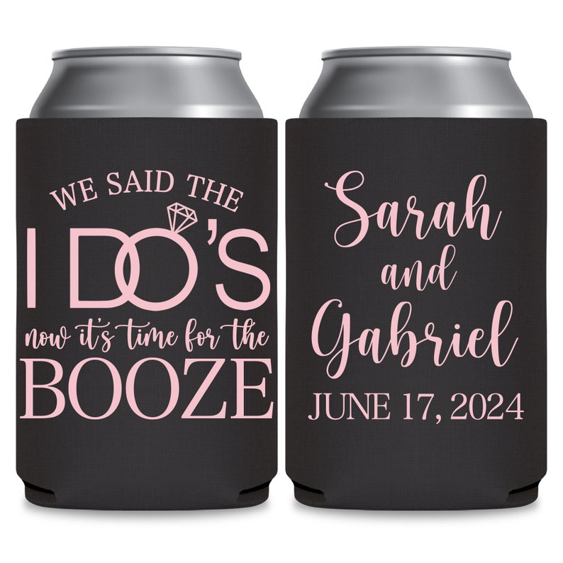 May include: Two black can coolers with pink text. The left cooler has the text 'We said the I DO'S now it's time for the BOOZE.' The right cooler has the text 'Sarah and Gabriel JUNE 17, 2024.'
