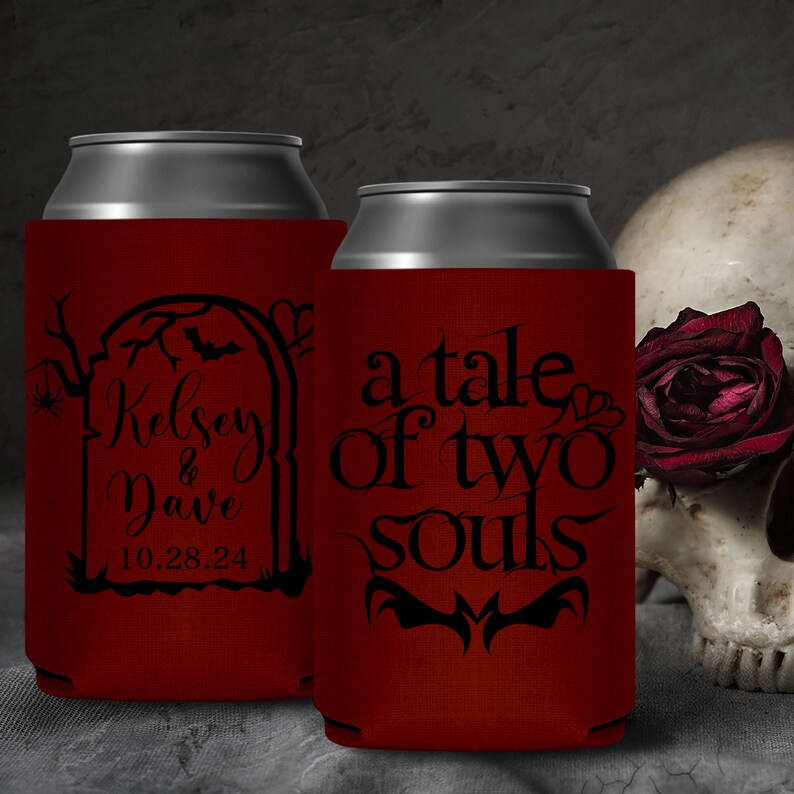 May include: Two red can coolers with black text. The cooler on the left has a tombstone with the text 'Kelsey & Dave 10.28.24'. The cooler on the right has the text 'a tale of two souls'.