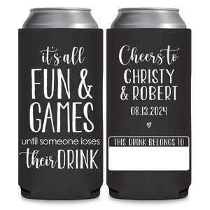 May include: Two black and white can coolers. The left cooler has the text 'it's all FUN & GAMES until someone loses their DRINK.' The right cooler has the text 'Cheers to CHRISTY & ROBERT 08.13.2024 ♡ THIS DRINK BELONGS TO' with a blank space for a name.