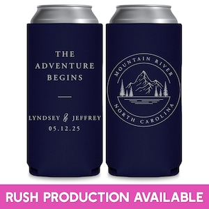 May include: Two blue can coolers with white text. The cooler on the left says 'The Adventure Begins' and 'Lyndsey & Jeffrey 05.12.25'. The cooler on the right has a circle with a mountain, river, and trees inside. The circle says 'Mountain River North Carolina'.