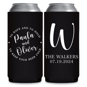 May include: Two black can coolers. The cooler on the left has white text that reads 'To have and to hold Paula and Oliver to keep your beer cold.' The cooler on the right has a white cursive letter 'W' and the text 'The Walkers 07.19.2024'.