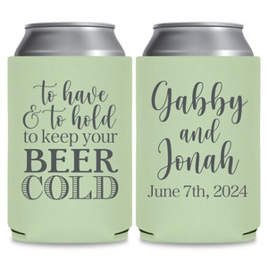 May include: Two green and silver can coolers. The cooler on the left has the text 'to have & to hold to keep your BEER COLD'. The cooler on the right has the text 'Gabby and Jonah June 7th, 2024'.