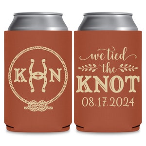 May include: Two brown and beige can coolers. The left cooler has a horseshoe and the letters K and N in a circle with a rope design. The right cooler has the text 'we tied the knot' with a floral design and the date '08.17.2024'.