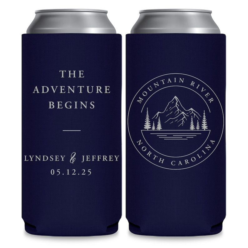 May include: Two navy blue can coolers with white text. The cooler on the left says 'The Adventure Begins' and 'Lyndsey & Jeffrey 05.12.25'. The cooler on the right has a circular design with a mountain, trees, and a river inside. The text around the design says 'Mountain River North Carolina'. 