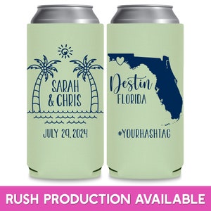 May include: Two green can coolers with a white background. The left cooler has a palm tree design with the text 'Sarah & Chris' and 'July 29, 2024'. The right cooler has a blue outline of the state of Florida with a heart in the center and the text 'Destin Florida' and '#YOURHASHTAG'.