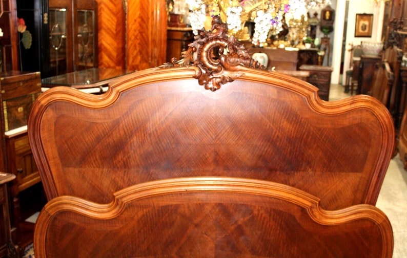 May include: A wooden headboard with a carved design and a rich brown finish. The headboard is made of wood with a decorative pattern.
