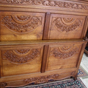May include: A vintage wooden armoire with intricate carvings. The armoire has four doors with carved floral designs and a decorative top.