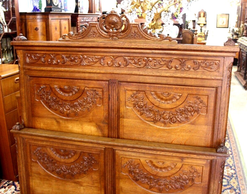 May include: A large, intricately carved wooden headboard with a decorative top and four panels. The headboard is made of a rich, dark wood and features floral and scrollwork designs.