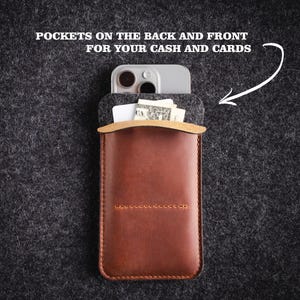 May include: A brown leather phone case with a gray felt lining. The case has a pocket on the back and front for cash and cards. "POCKETS ON THE BACK AND FRONT FOR YOUR CASH AND CARDS" is written in white text on a black background.
