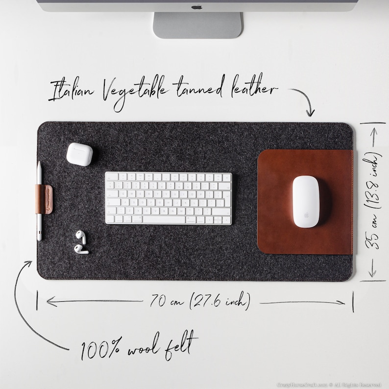 May include: A gray felt desk mat with a brown leather mousepad. The mat measures 27.6 inches wide and 13.8 inches long. It is made of 100% wool felt and has a leather border. The text "Italian Vegetable tanned leather" is written above the mat.