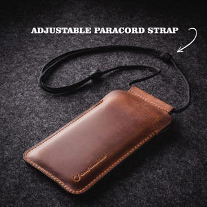 May include: A brown leather phone case with an adjustable paracord strap. The case has the text "Crazy Horse Craft" embossed on it.