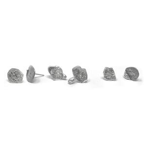 May include: Five silver earrings with unique, textured, and abstract shapes. The earrings are all different sizes and have a rough, organic look.