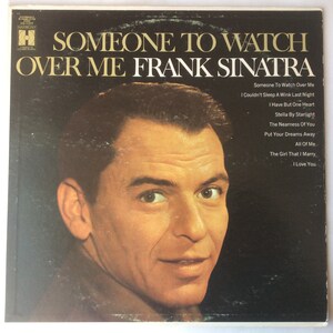 Puede incluir: Una portada de álbum de vinilo vintage con Frank Sinatra. El título del álbum es "Someone To Watch Over Me" y la portada del álbum presenta una foto de primer plano de Frank Sinatra.