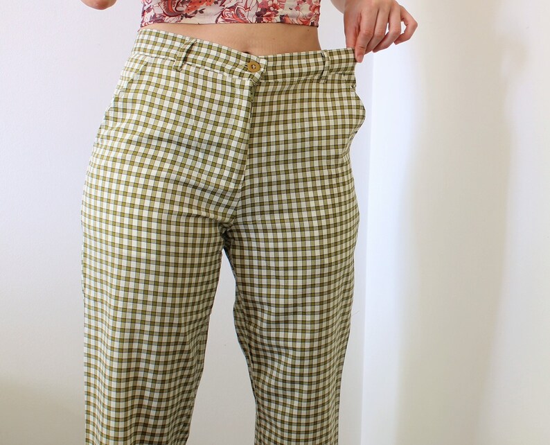 Pu&ograve; includere: Pantaloni a quadri verdi e bianchi. I pantaloni hanno una chiusura con bottoni e un design classico a gamba dritta. Il tessuto presenta un motivo a quadretti nei toni del verde e del bianco. I pantaloni sono di stile casual.