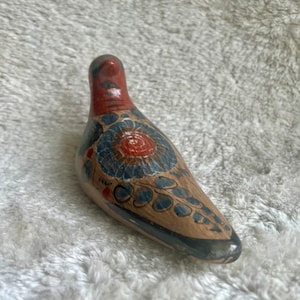 Vintage hand painted Tonala Mexican folk art bird figure with floral design in warm red and brown tones.