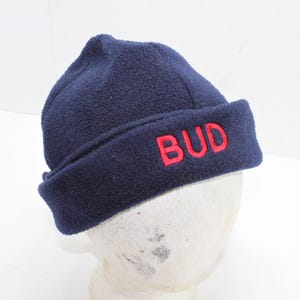 May include: A navy blue fleece beanie with a red embroidered "BUD" logo.