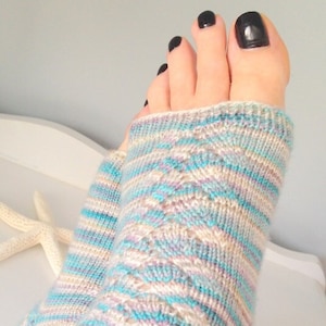 Puede incluir: Un par de calcetines de punto con un patrón de rayas azules, blancas y rosas. Los calcetines están hechos con un punto de cable y tienen una sensación suave y cómoda.
