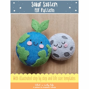 Puede incluir: Un patrón PDF para coser una Tierra y una Luna de fieltro. La Tierra es azul con continentes verdes y una cara sonriente. La Luna es gris con una cara dormida. El patrón incluye instrucciones ilustradas paso a paso y plantillas de tamaño real. "What a curly life" está impreso debajo de la imagen.