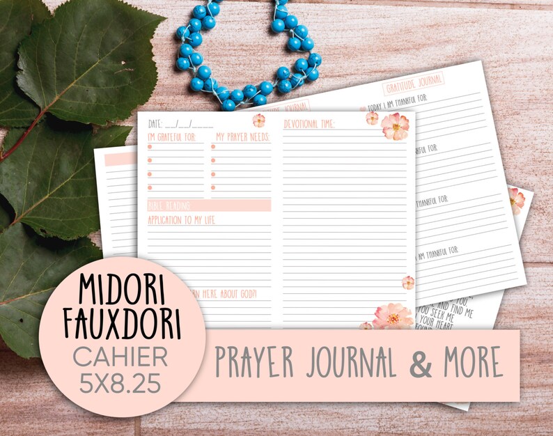 May include: A pink and white prayer journal with a floral design. The journal is labeled "Midori Fauxdori Cahier 5x8.25" and "Prayer Journal & More".