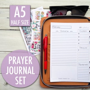 May include: A brown leather A5 half-size prayer journal with a red pen and stickers. The journal has a section for Bible reading, devotional time, things you are grateful for, a memory verse, and prayer requests.