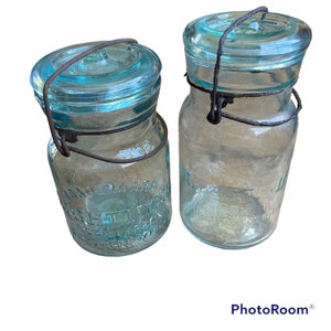 antique vtg Lightning jars Putnam 7 and 87 Glass Canning Farmhouse. Aqua glass with bubbles!Condition: one bail is rusted and broken