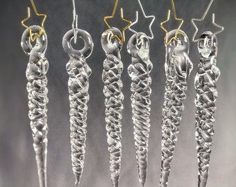 May include: Seven clear glass icicle ornaments with gold star tops hanging from silver and gold wires.