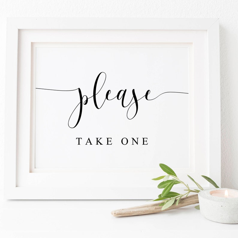 May include: A white framed sign with black calligraphy that reads "please take one".