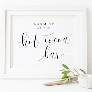 May include: White framed sign with black calligraphy text that reads "Warm Up At The Hot Cocoa Bar".