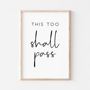 May include: A black and white printable wall art print with the text "This too shall pass" in a modern calligraphy font.