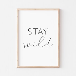 May include: A framed print with the text "STAY wild" in black script font on a white background.