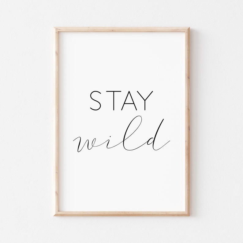 May include: A framed print with the text "STAY wild" in black script font on a white background.