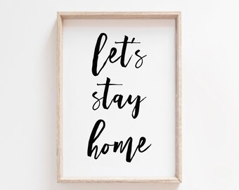 May include: A framed print with the text "Let's stay home" in black calligraphy on a white background.