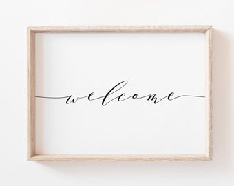 May include: A framed print with the word "welcome" written in cursive script on a white background.