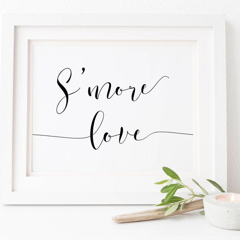 May include: A white framed print with black calligraphy that reads "S'more love" on a white background.