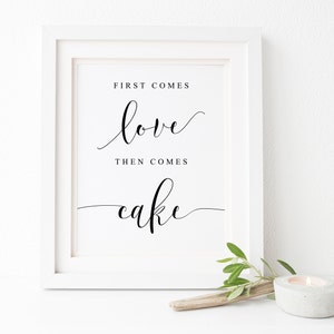 Peut inclure: Impression encadrée blanche avec calligraphie noire qui dit "First comes love, then comes cake".