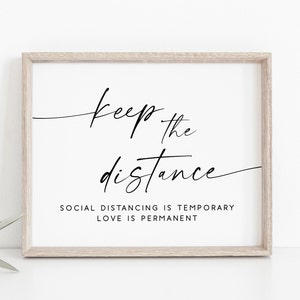 May include: A framed print with the text "Keep the distance. Social distancing is temporary. Love is permanent." in black script font on a white background.